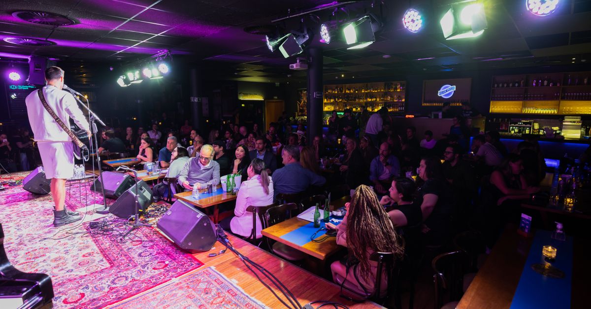 A vibrant live music performance captured in a cozy, bustling club atmosphere.